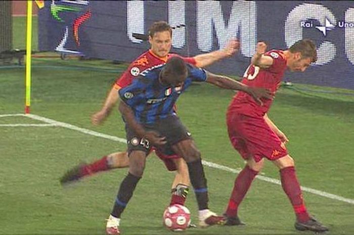 Eks striker Inter Milan, Mario Balotelli, memeluk kapten legendaris AS Roma, Francesco Totti, usai menendang dirinya sampai berujung kartu merah.