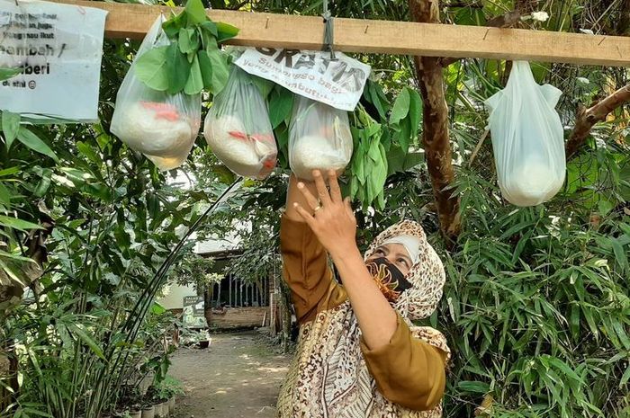 Ardiati saat menggantung plastik berisi sembako di depan rumahnya di Kabupaten Sleman Yogyakarta 