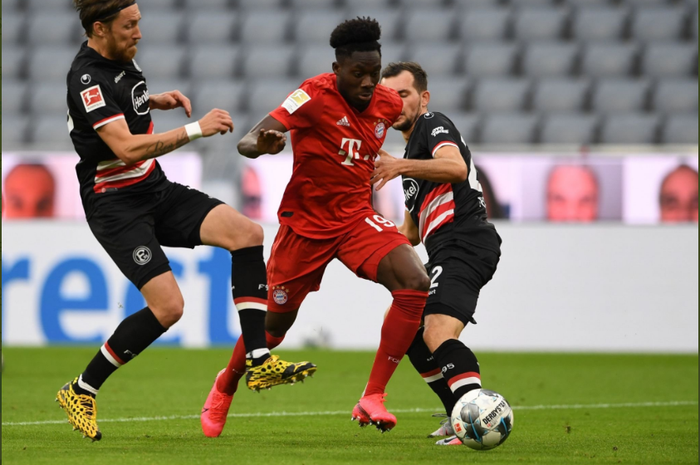 Alphonso Davies mencoba melewati dua pemain dalam laga Bayern Muenchen vs Fortuna Dusseldorf, Sabtu (30/5/2020) malam hari WIB.