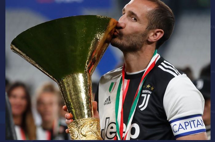 Giorgio Chiellini mencium trofi juara Liga Italia milik Juventus.