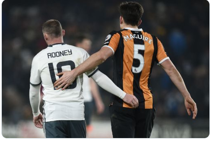 Wayne Rooney (kiri) berdampingan dengan Harry Maguire dalam sebuah pertandingan.