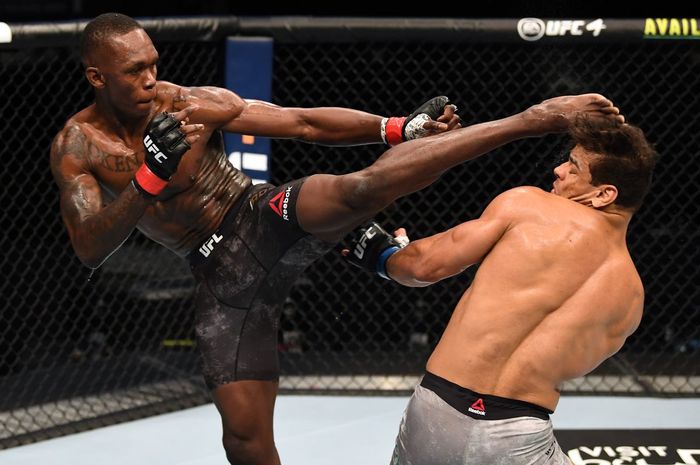 Israel Adesanya (kiri) saat mencoba menyepak Paulo Costa di UFC 253 September lalu.