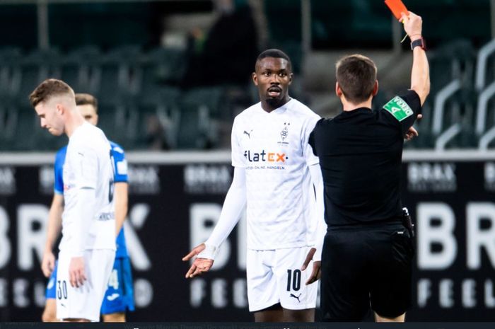 Penyerang Borussia Moenchengladbach, Marcus Thuram, diusir wasit karena meludahi wajah seorang pemain Hoffenheim.