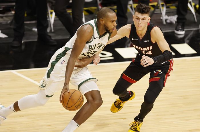 Small forward Milwaukee Bucks, Khris Middleton, berupaya melewati penjagaan dari pemain Miami Heat, Tyler Herro, pada lanjutan musim reguler NBA 2020-2021 di American Airlines Arena, Rabu (30/12/2020) pagi WIB.