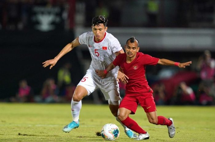 Bek kiri Timnas U-22 Vietnam Doan Van Hau (kiri) bersaing dengan pemain Timnas U-22 Indonesia Riko Simanjuntak dalam final SEA Games 2019 di Filipina.