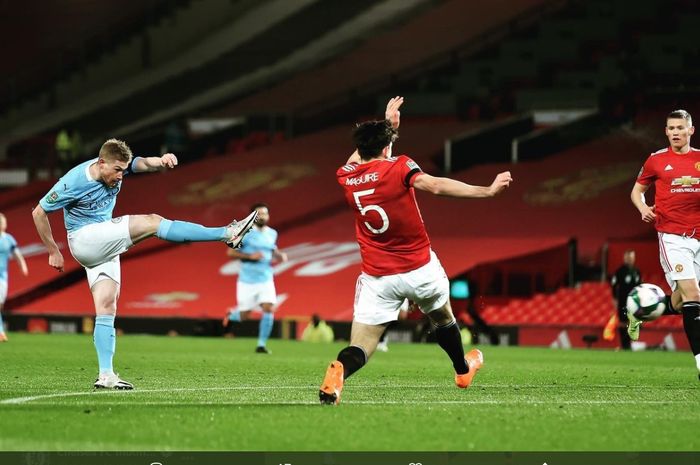 Momen Kevin De Bruyne melepaskan tembakan yang coba dihalau Harry Maguire pada laga Piala Liga Inggris atau Carabao Cup yang mempertemukan Manchester United dan Manchester City di Old Trafford.