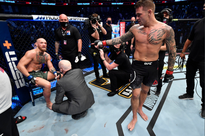 Dustin Poirier (kanan) menghampiri Conor McGregor (kiri) setelah selesai pertarungan UFC 257.