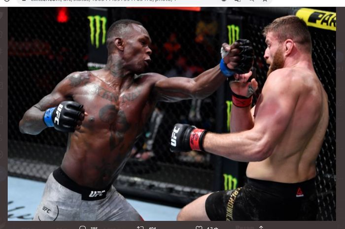 Juara kelas menengah UFC, Israel Adesanya, saat hendak memukul Jan Blachowicz yang terpojok sisi pagar. Kedua petarung saling terlibat bentrok pada ajang UFC 259 di UFC Apex, Las Vegas, Nevada, Amerika Serikat, Minggu (7/3/2021).