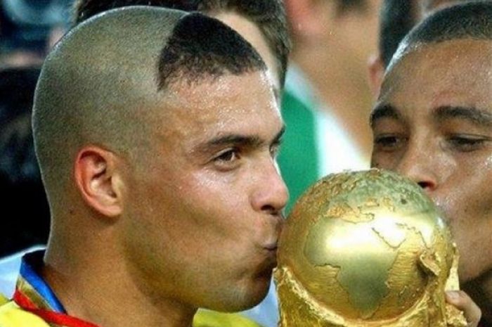 Legenda timnas Brasil, Ronaldo Nazario, dengan rambut ikoniknya, menciup trofi Piala Dunia 2002