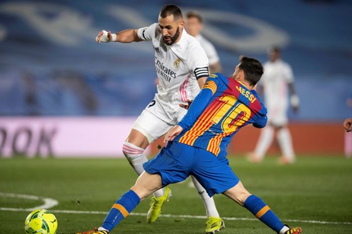 Karim Benzema dan Lionel Messi berebut bola dalam pertandingan Real Madrid kontra Barcelona di LaLiga.