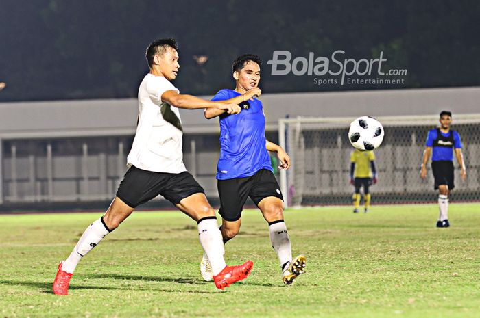 Andy Setyo (kiri) berusaha menghalau bola yang nyaris dikuasai oleh Kadek Agung (kanan) dalam sesi latihan timnas Indonesia di Stadion Madya, Senayan, Jakarta, 11 Mei 2021.