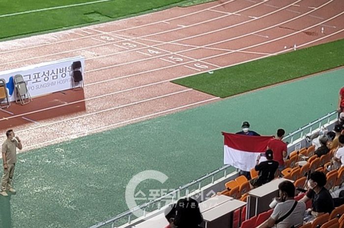 Salah seorang WNI tertangkap kamera tengah mengibarkan bendera Merah Putih di laga Ansan Greeners vs Busan IPark, Sabtu (17/7/2021).