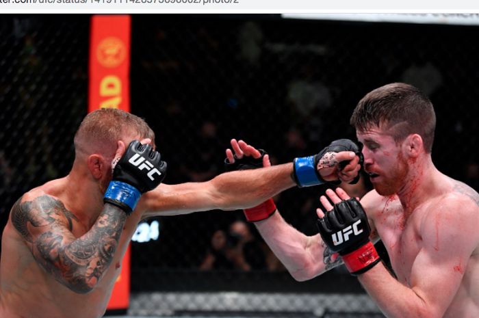 T.J Dillashaw (kiri) saat memukul Cory Sandhagen pada acara utama UFC Vegas 32, di Las Vegas, Amerika Serikat, Minggu (25/7/2021).