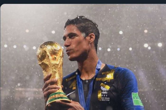 Raphael Varane mencium trofi Piala Dunia 2018 setelah juara bersama timnas Prancis.