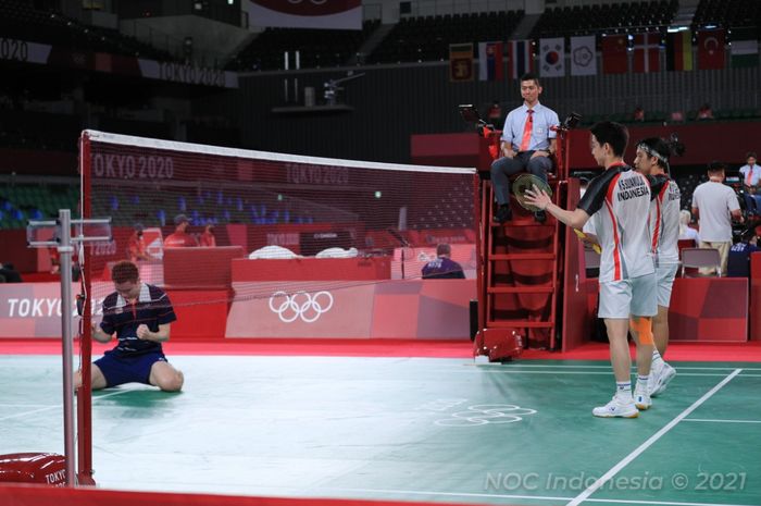 Pasangan ganda putra Indonesia, Marcus Fernaldi Gideon/Kevin Sanjaya Sukamuljo, memberi gestur selamat dengan raket mereka kepada Aaron Chia/Soh Wooi Yik (Malaysia) usai pertandingan perempat final Olimpiade Tokyo 2020 di Musashino Forest Sport Plaza, Tokyo, Jepang, Kamis (29/7/2021).