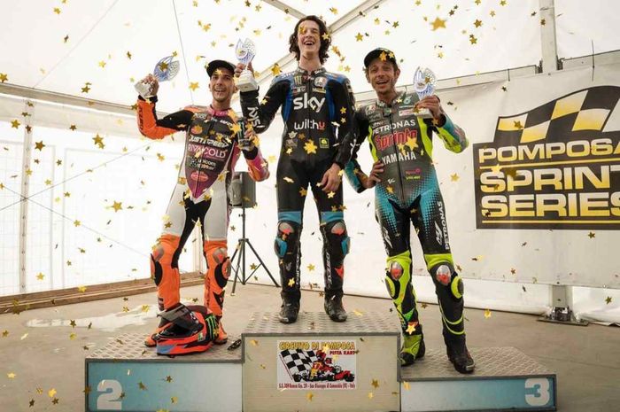 Pembalap legendaris MotoGP, Valentino Rossi, berpose di podium setelah finis di urutan ketiga dalam balapan internal bersama para muridnya di Akademi VR46.