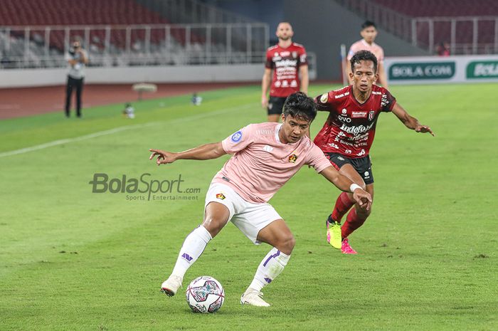 Pemain Persik Kediri, Hariyanto Panto (kiri) sedang menguasai bola dan dibayangi-bayangi juga oleh pilar Bali United, Muhammad Rahmat, di Stadion Gelora Bung Karno, Senayan, Jakarta, 27 Agustus 2021.