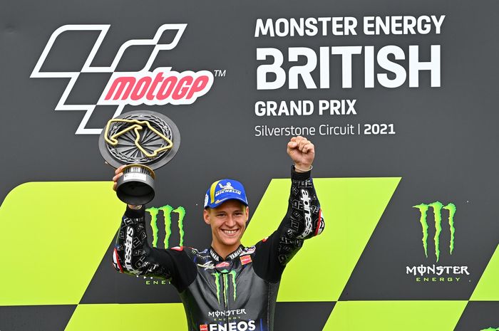 Pembalap Monster Energy Yamaha, Fabio Quartararo, berpose di podium juara MotoGP Inggris di Sirkuit Silverstone, Minggu (29/8/2021).