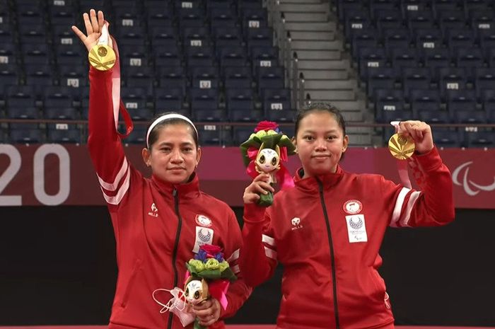 Pasangan ganda putri Indonesia, Leani Ratri Oktila/Khalimatus Sadiyah, berpose dengan medali emas kelas SL3-SU5 di Yoyogi National Stadium, Tokyo, Jepang, Sabtu (4/9/2021).