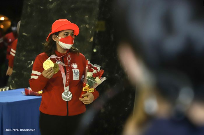 Atlet para bulu tangkis putri Indonesia, Leani Ratri Oktila, berpose dengan medali emas Paralimpiade Tokyo 2021 setibanya di Bandara Soekarno-Hatta, Cengkareng, Banten, Senin (6/9/2021) malam.