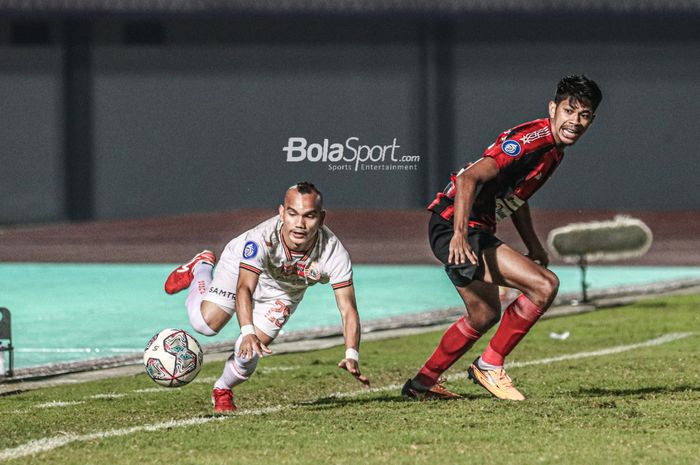 Pemain Persija Jakarta, Riko Simanjuntak (kiri), sedang mengejar bola dan dikawal pilar Persipura Jayapura, Irsan Rahman Lestaluhu (kanan), dalam laga pekan ketiga Liga 1 2021 di Stadion Indomilk Arena, Tangerang, Banten, 19 September 2021.