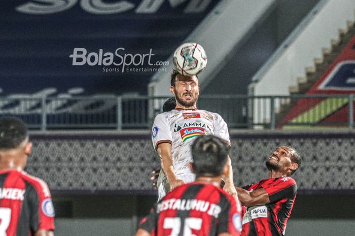 Bek Persija Jakarta, Marco Motta (kiri), sedang berduel udara dengan pemain Persipura Jayapura, Israel Wamiau (kanan), dalam laga pekan ketiga Liga 1 2021 di Stadion Indomilk Arena, Tangerang, Banten, 19 September 2021.