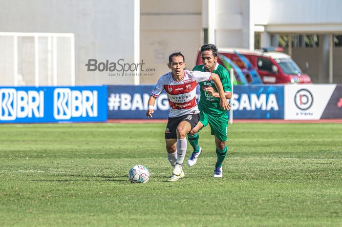 Gelandang Madura United, Slamet Nurcahyo (kiri), sedang menguasai bola dan dibayangi oleh pemain PSS Sleman, Wahyu Sukarta (kanan), dalam laga pekan keempat Liga 1 2021 di Stadion Madya, Senayan, Jakarta, 25 September 2021.