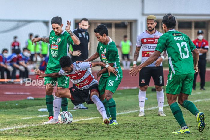 Dua pemain PSS Sleman, Irfan Bachdim (kiri) dan Misbakus Solikin (kanan), sedang berusaha merebut bola yang dikuasai pilar Madura United, Alfin Tuasalamony (tengah), dalam laga pekan keempat Liga 1 2021 di Stadion Madya, Senayan, Jakarta, 25 September 2021.