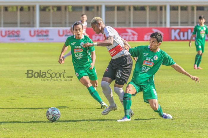 Gelandang Madura United, Hugo Gomes Dos Santos Silva alias Jaja (tengah), sedang menguasai bola dan dibayangi dua pemain PSS Sleman, Samsul Arifin (kiri) dan Wahyu Sukarta dalam laga pekan keempat Liga 1 2021 di Stadion Madya, Senayan, Jakarta, 25 September 2021.