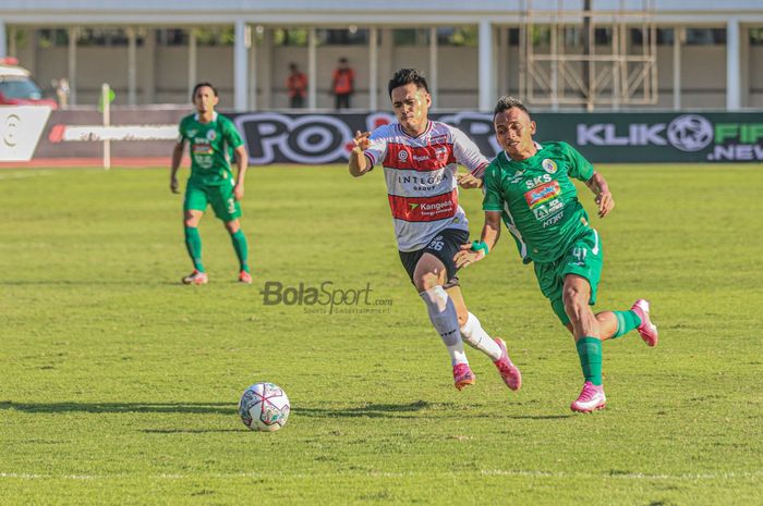 Bek sayap kiri Madura United, Novan Sasongko (kiri), sedang berebut bola dengan pemain PSS Sleman, Irfan Jaya (kanan), dalam laga pekan keempat Liga 1 2021 di Stadion Madya, Senayan, Jakarta, 25 September 2021.