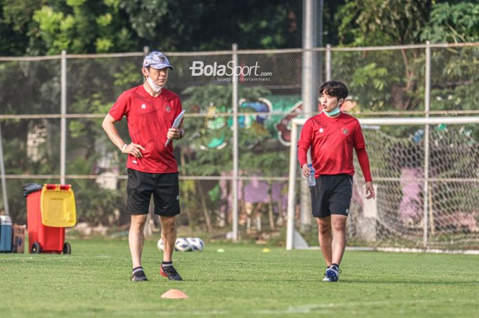 Pelatih timnas Indonesia, Shin Tae-yong (kiri) dan penerjemahnya, Jeong Seok-seo (kanan), sedang memantau timnya yang berlatih di Lapangan G (Panahan), Senayan, Jakarta, 2 Oktober 2021.