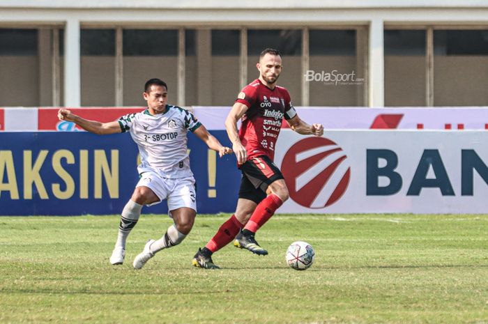 Striker Bali United, Ilija Spasojevic (kanan), sedang menguasai bola dan dibayangi oleh bek Tira Persikabo, Andy Setyo (kiri), dalam laga pekan keenam Liga 1 2021 di Stadion Madya, Senayan, Jakarta, 2 Oktober 2021.