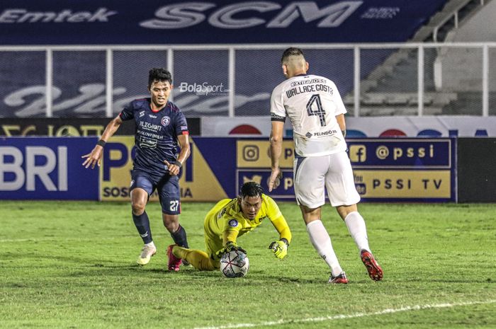 Penyerang Arema FC, Dedik Setiawan (kiri), sedang berebut bola dengan kiper PSIS Semarang, Joko Ribowo (tengah), dalam laga pekan keempat Liga 1 2021 di Stadion Madya, Senayan, Jakarta,  25 September 2021.