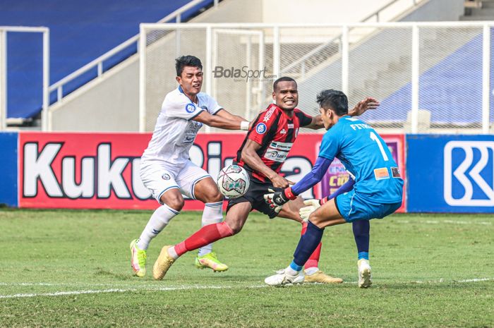 Penyerang Arema FC, Dedik Setiawan (kiri), sedang berebut bola dengan bek Persipura Jayapura, Israel Wamiau (tengah), dalam laga pekan kelima Liga 1 2021 di Stadion Madya, Senayan, Jakarta, 29 September 2021.