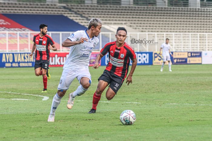 Pemain sayap kiri Arema FC, Kushedya Hari Yudo (kiri), sedang menguasai bola dan dibayangi gelandang Persipura Jayapura, Muhammad Tahir (kanan), dalam laga pekan kelima Liga 1 2021 di Stadion Madya, Senayan, Jakarta, 29 September 2021.