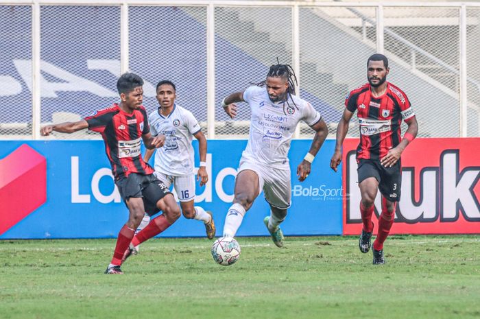 Striker Arema FC, Carlos Fortes (tengah), sedang menguasai bola dan dibayangi dua pemain Persipura Jayapura, Irsan Rahman Lestaluhu (kiri) dan Donni Harold Monim (kanan), dalam laga pekan kelima Liga 1 2021 di Stadion Madya, Senayan, Jakarta, 29 September 2021.