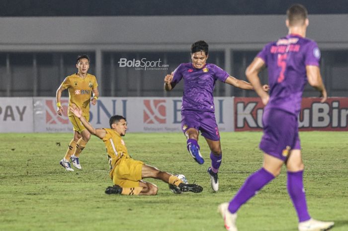 Gelandang Bhayangkara FC, Teuku Muhammad Ichsan alias TM Ichsan (kiri), nampak sedang menekel bola yang dikuasai pemain Persik Kediri, Ahmad Agung  Setia Budi (kanan), dalam laga pekan kelima Liga 1 2021 di Stadion Madya, Senayan, Jakarta, 29 September 2021.