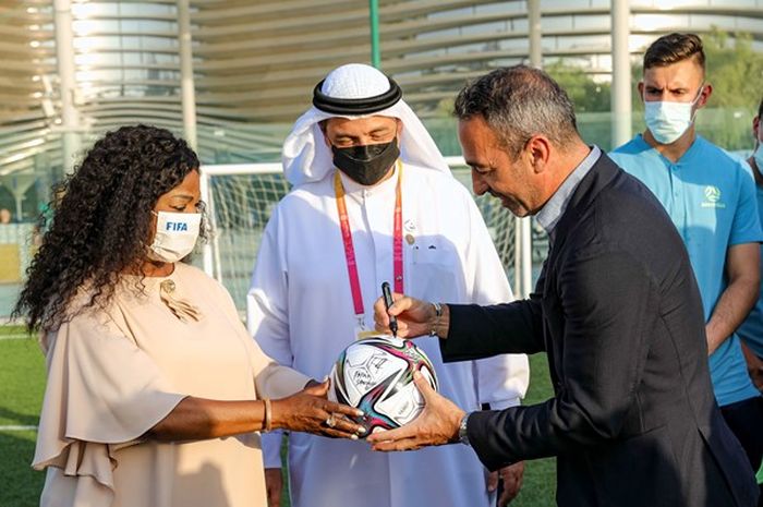 Sekretaris Jenderal FIFA, Fatima Samoura, bersama dengan Direktur Eksekutif Biro Expo, Najeeb Al-Ali, dan Komisioner Umum Paviliun Australia, Justin McGowan, saat mengunjungi timnas U-23 Australia di Dubai, UEA.