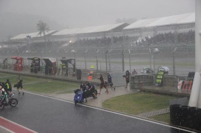 Suasana saat para pebalap dan kru tim tergesa-gesa kembali ke paddock di tengah hujan deras yang mengguyur kawasan Sirkuit Mandalika jelang Race 1 kelas World Superbike, Sabtu (20/11/2021). 