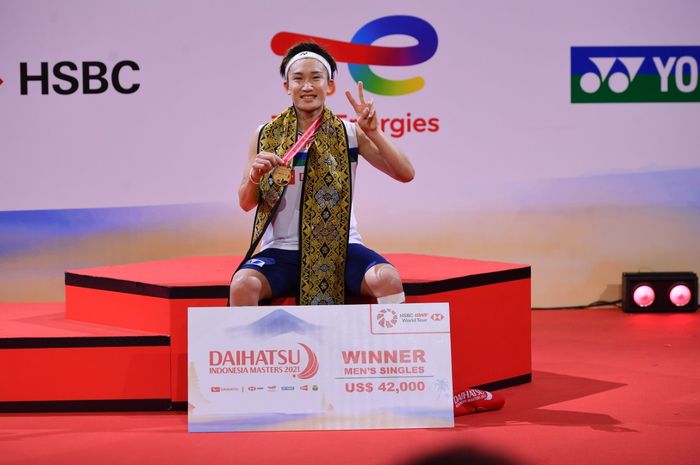 Pebulu tangkis tunggal putra Jepang, Kento Momota, berpose di podium setelah memenangi gelar Indonesia Masters 2021 di Bali International Convention Centre, Nusa Dua, Minggu (21/11/2021).