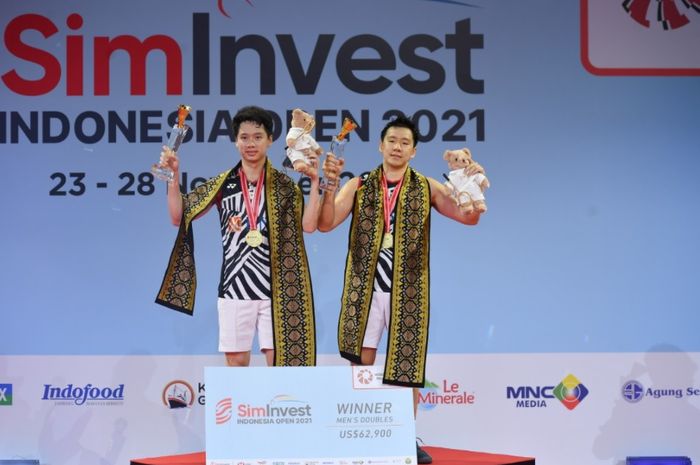 Pasangan ganda putra Indonesia, Marcus Fernaldi Gideon/Kevin Sanjaya Sukamuljo, berdiri di podium juara setelah memenangi final Indonesia Open 2021 yang digelar di Bali International Convention Centre, Bali, 28 November 2021.