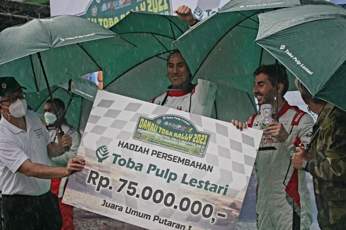 Pembalap Sean Gelael (tengah) merayakan kemenangan Putaran I Kejurnas Reli Danau Toba 2021.