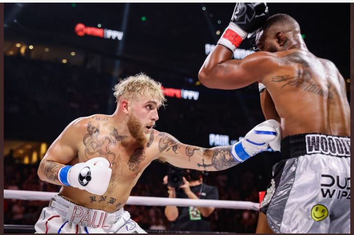 Momen Jake Paul (kiri) melakukan body shot ke arah Tyron Woodley (kanan) dalam duel ulang antara mereka berdua di Amalie Arena, Tampa, Florida, Amerika Serikat, Sabtu (18/12/2021).