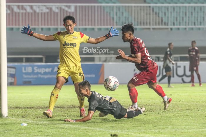 Kiper Dewa United, Rivky Mokodompit (kiri), sedang mengamankan gawangnya dari bola yang dikuasai pemain Persis Solo, Heri Susanto (kanan), dalam laga semifinal Liga 2 2021 di Stadion Pakansari, Bogor, Jawa Barat, 27 Desember 2021.