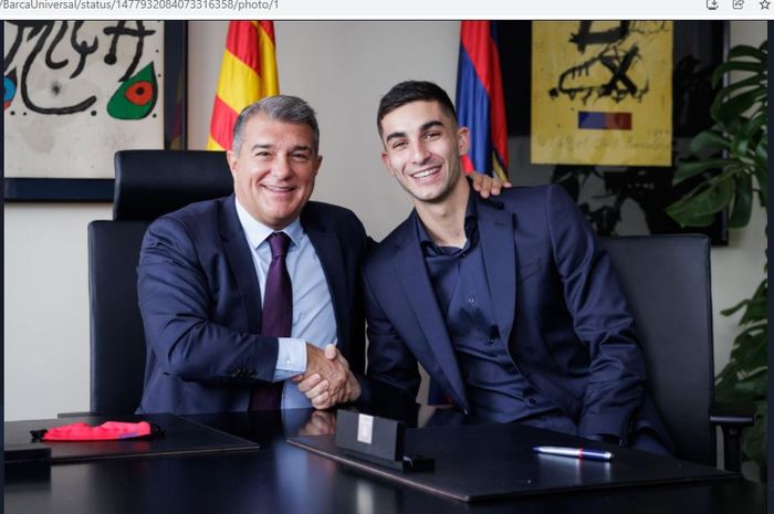 Ferran Torres berpose dengan presiden Barcelona, Joan Laporta.