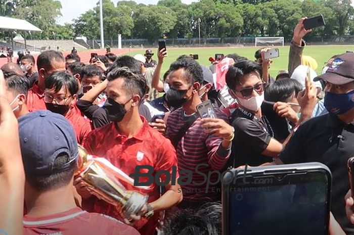 Pemain Persis Solo, Shulton Fajar merayakan juara Liga 2 2021 dengan memamerkan trofi ke suporternya di Stadion Sriwedari, Surakarta, Minggu (9/1/2022).