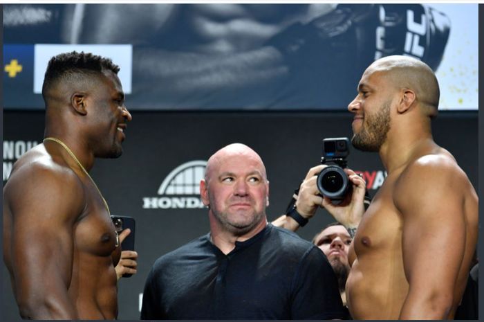 Ketika Francis Ngannou (kiri) dan Ciryl Gane (kanan) melakukan sesi face-off setelah proses penimbangan badan pada Jumat (21/1/2022) waktu setempat. Pertemuan tatap wajah Ngannou dan Gane ditengahi Presiden UFC, Dana White (tengah).