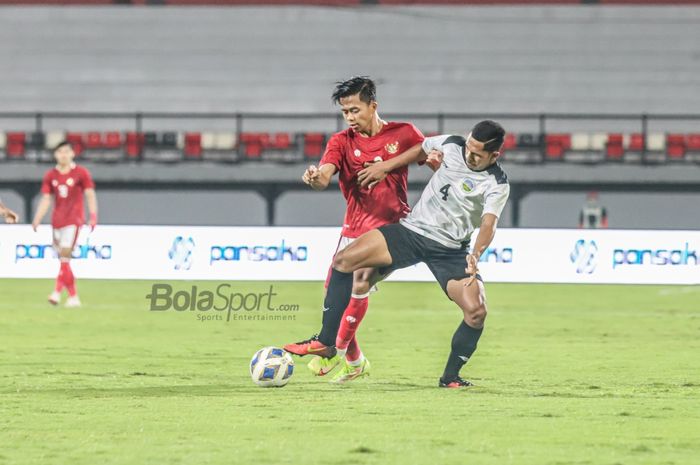 Bek sayap kiri timnas Indonesia, Edo Febriansyah (kiri), sedang berebut bola dengan pemain timnas Timor Leste, Jaimito Antonio (kanan),  di Stadion Kapten I Wayan Dipta, Gianyar, Bali, 27 Januari 2022.