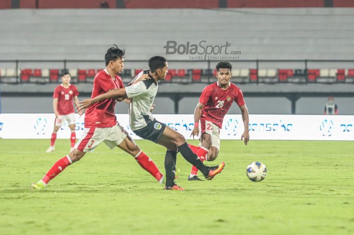 Dua pemain timnas Indonesia, Edo Febriansyah (kiri) dan Ramai Rumakiek (kanan), sedang mencoba menghalau bola yang dikuasai salah satu pemain timnas Timor Leste  di Stadion Kapten I Wayan Dipta, Gianyar, Bali, 27 Januari 2022.