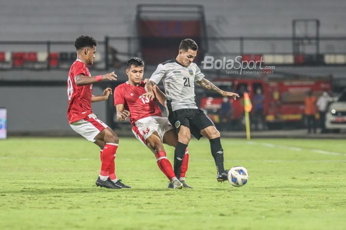 Pemain timnas Indonesia, Rachmat Irianto (tengah), sedang membayangi pergerakan pilar timnas Timor Leste, Paulo Gali Freitas (kanan),  di Stadion Kapten I Wayan Dipta, Gianyar, Bali, 27 Januari 2022.